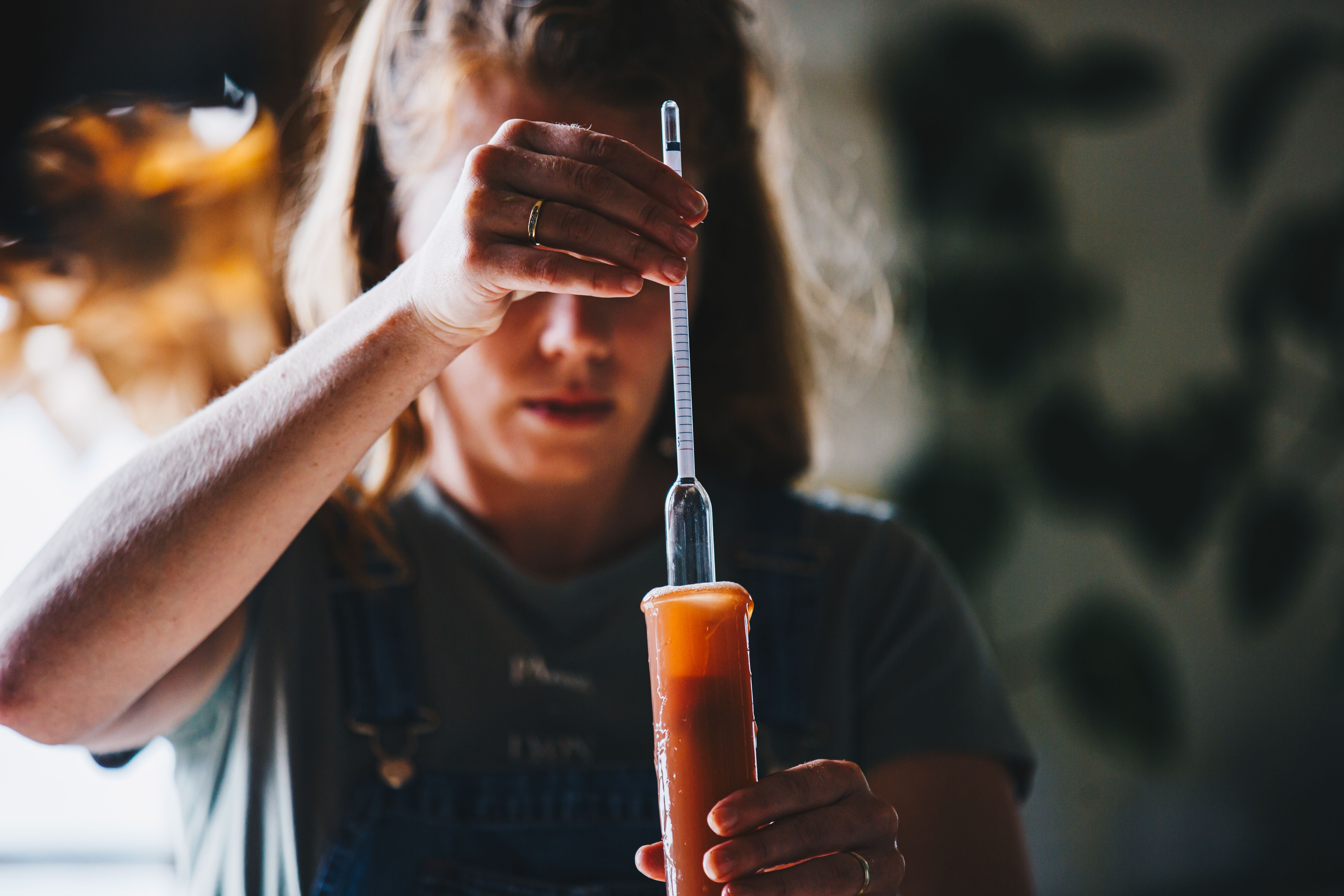 Woman measuring alcohol content in brewery